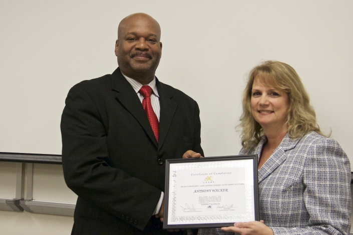 Anthony Walker receiving graduation certificate from Brenda Dilts, Class Facilitator