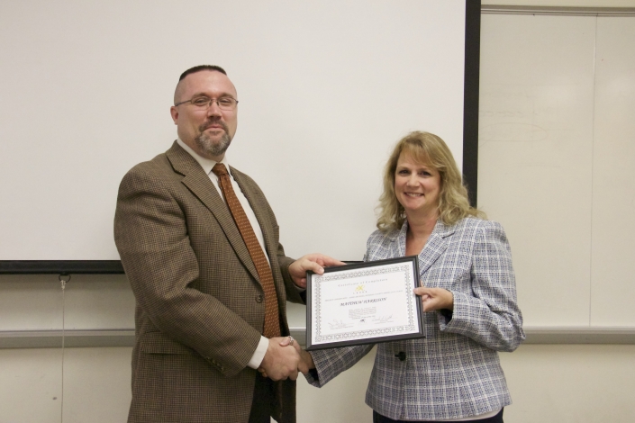 Matthew Harrison receiving graduation certificate from Brenda Dilts, Class Facilitator