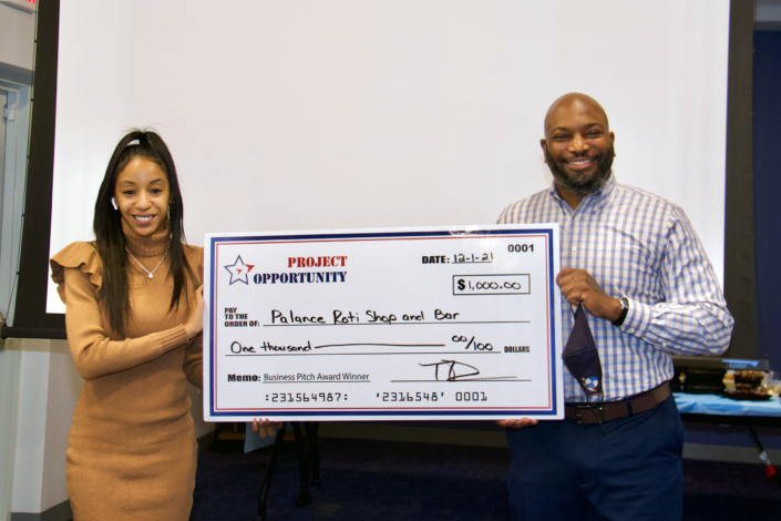 Business Pitch Award Check Presentation Left to Right: Tiffany Davis Course Facilitator; Sean Andre Stephen, Owner Palance Roti Shop and Bar