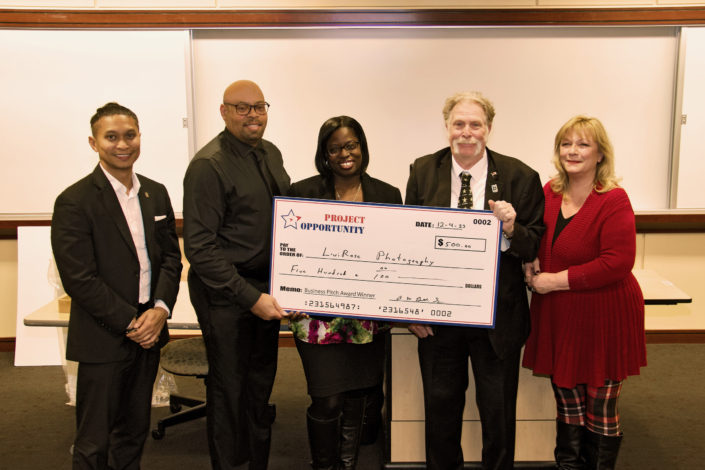 Check Presentation to Veron Smith, 2nd Place Business Pitch Left to Right: Emmyrich Vicente (PNC Bank and Business Pitch Judge); Anthony Butler Sr. Course Facilitator; Joanna Starling; Joe Giordano Project Opportunity<sup>SM</sup> Founder, and Kim McGettigan (Montgomery College and Business Pitch Judge)